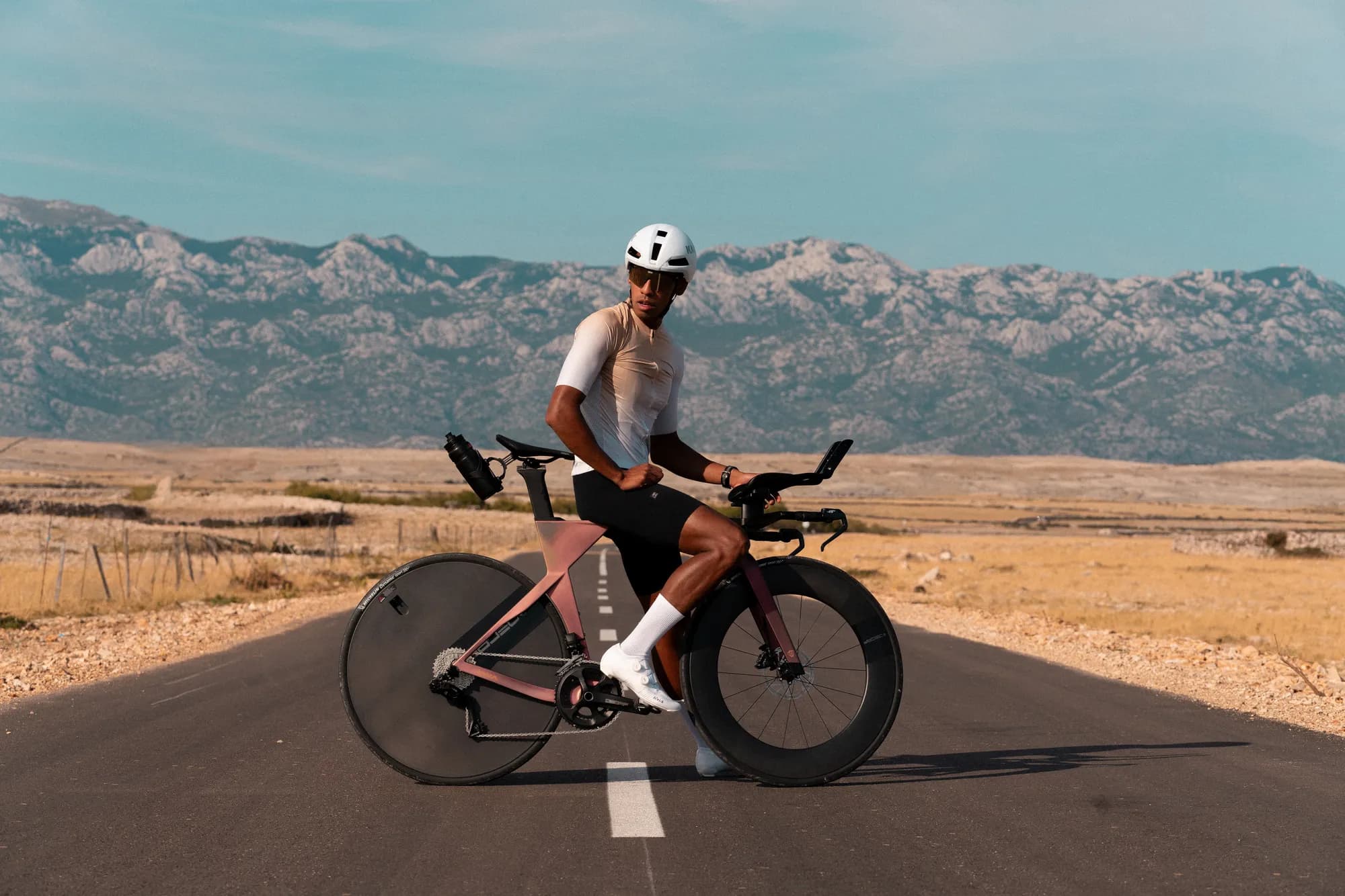 Ciclista junto a la Java Vega TT en una carretera de montaña